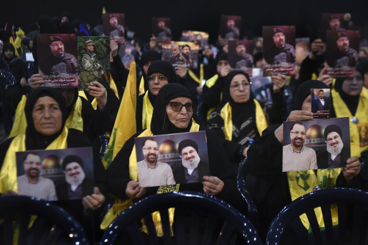 Hezbollah supporters hold portraits that show Hezbollah leader Sayyid Hassan Nasrallah a