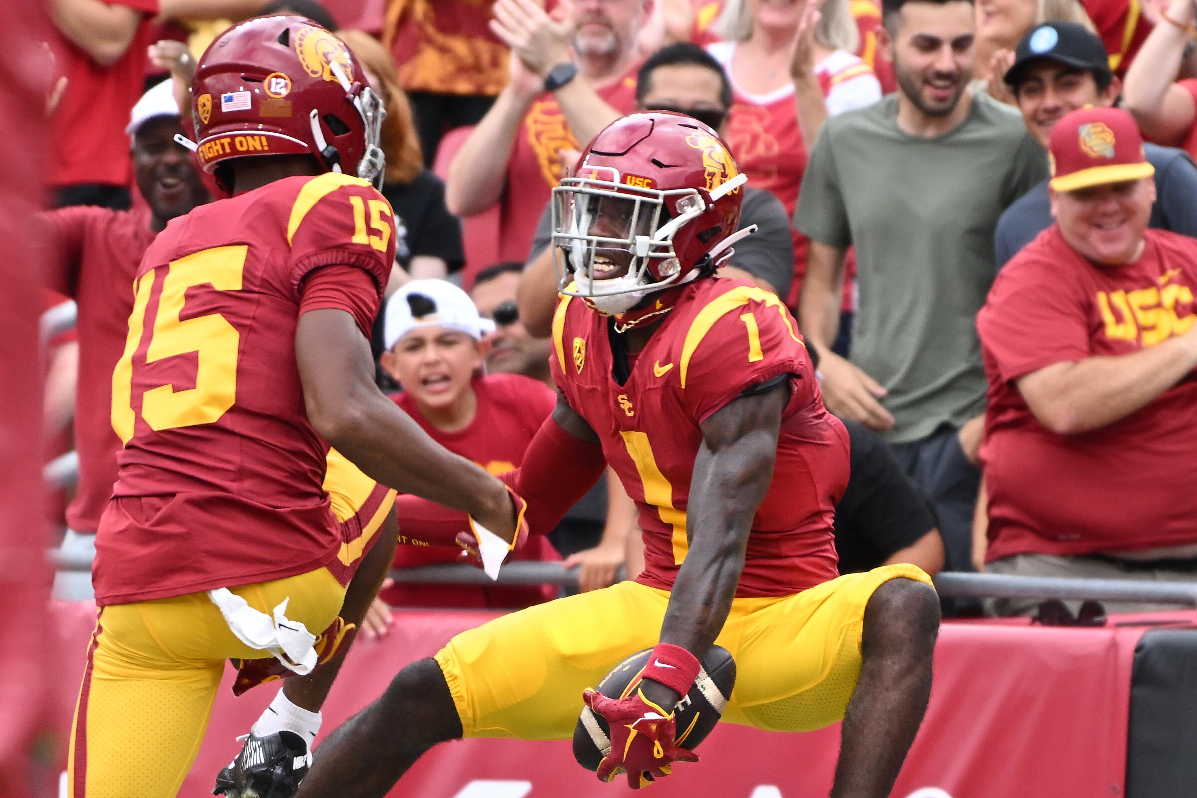 USC wide receiver Zachariah Branch celebrates with teammate Dorian Singer after making a touchdown catch.