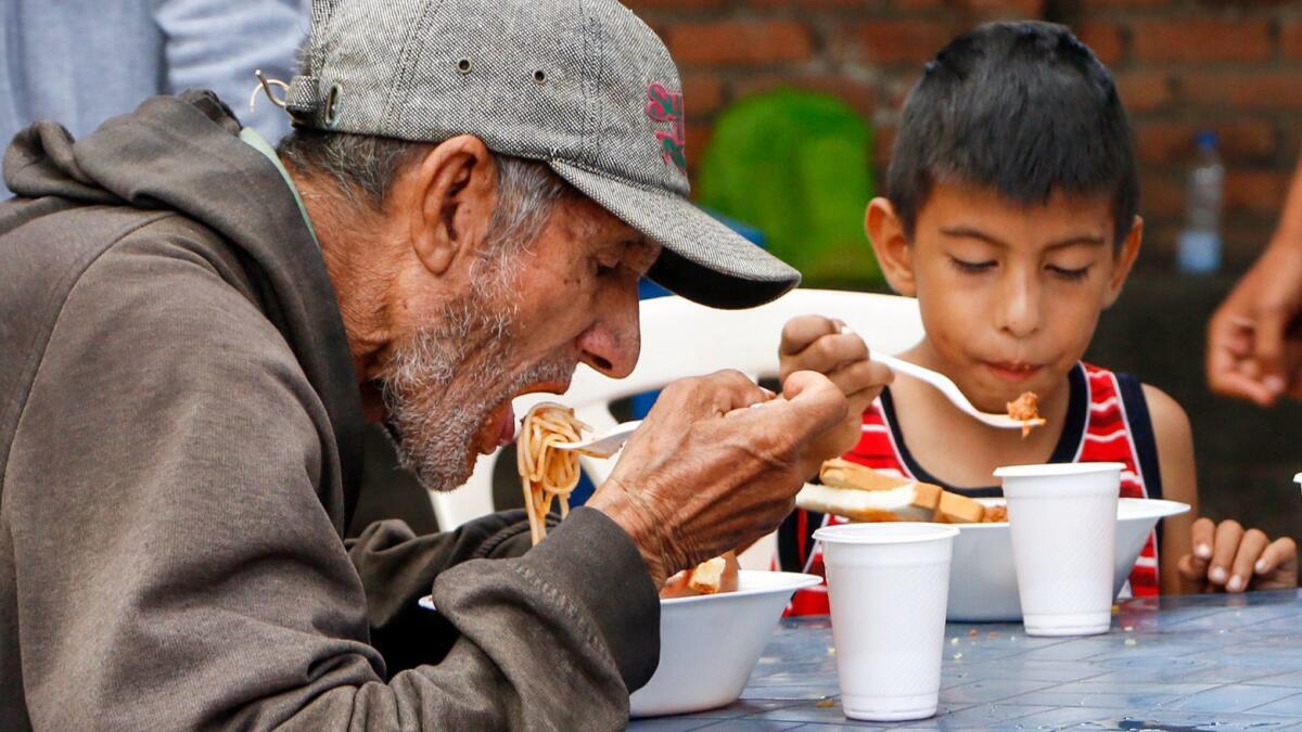 Venezuelans get food at the Casa de Paso Divina Providencia refuge in Cucuta, Colombia. They are among thousands who have fled the country.