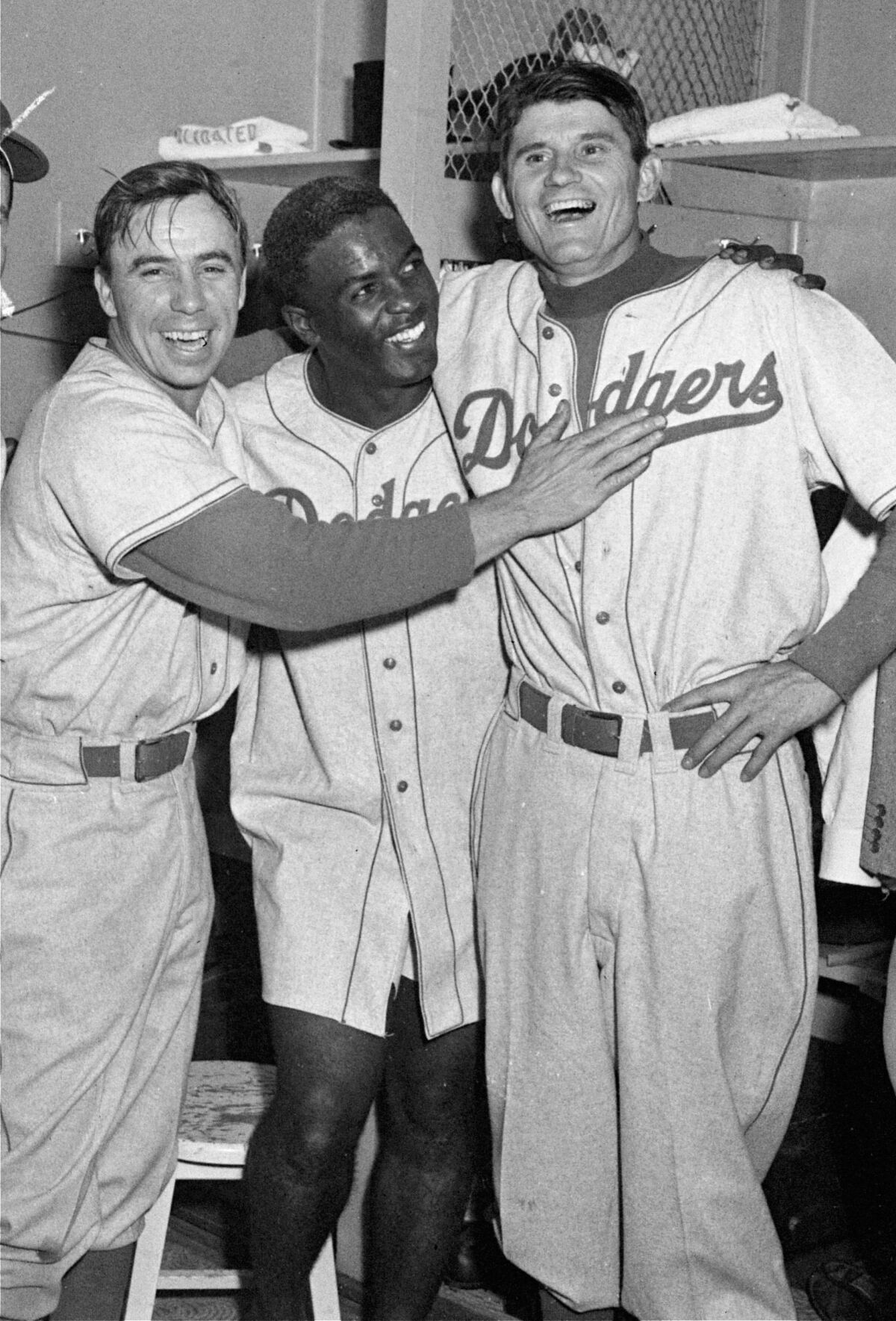 Brooklyn Dodgers players Pee Wee Reese, Jackie Robinson, and Preacher Roe, left to right, are a happy trio in 1952.