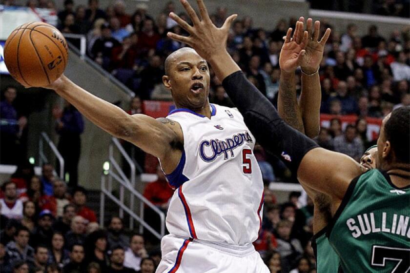 Caron Butler dishes off a pass around Celtics defenders.