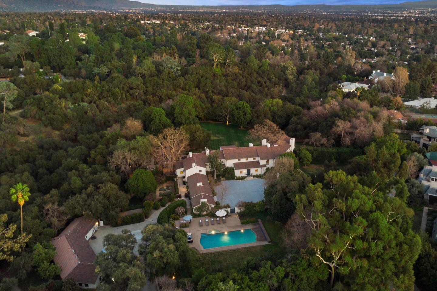 Aerial view of the estate with pool and surrounded by trees.