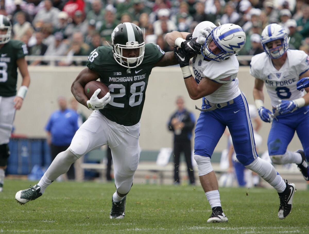 Michigan State running back Madre London (28) rushes against Air Force defensive back Hayes Linn during the first quarter of a game on Sept. 19.