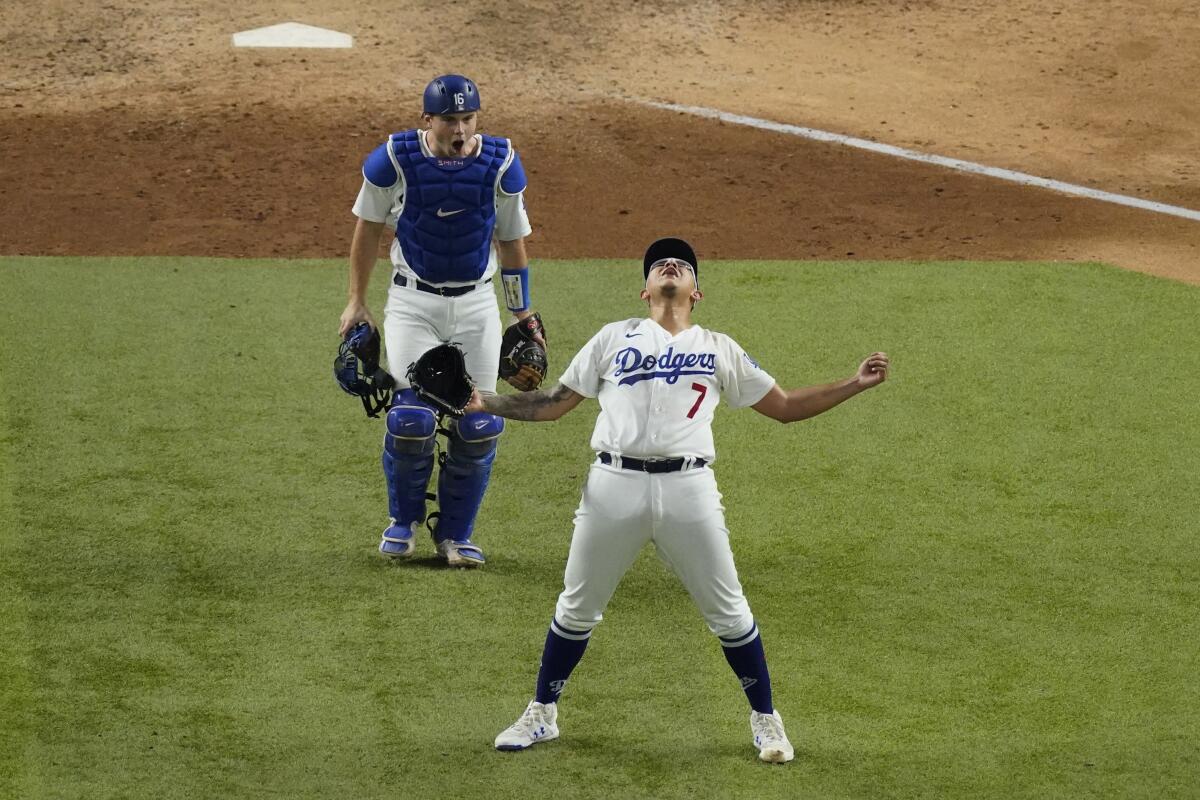 Dodgers pitcher Julio Urías celebrates in front of catcher Will Smith.