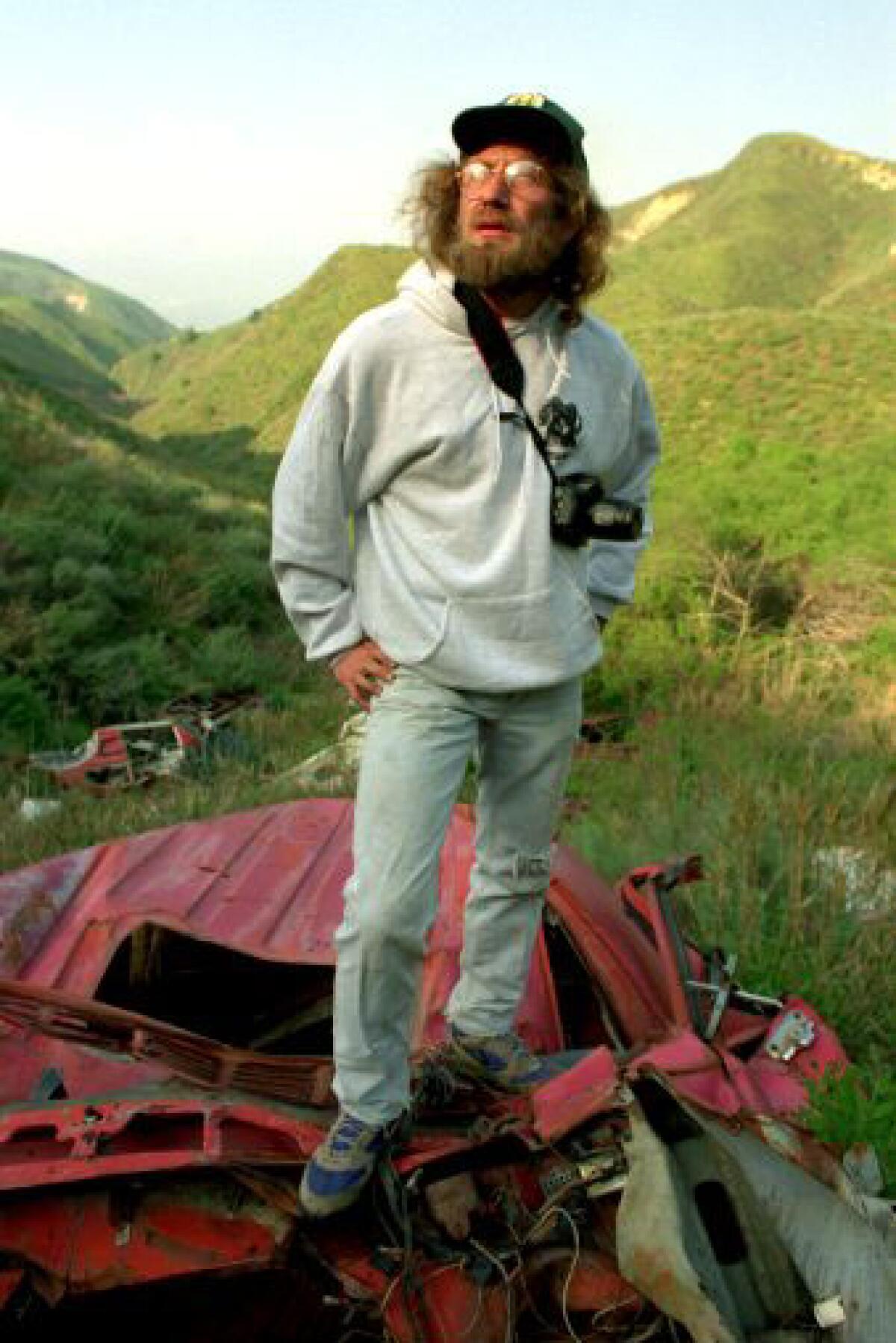 Scott Mathes stands on top of car dumped into Balcolm Canyon.