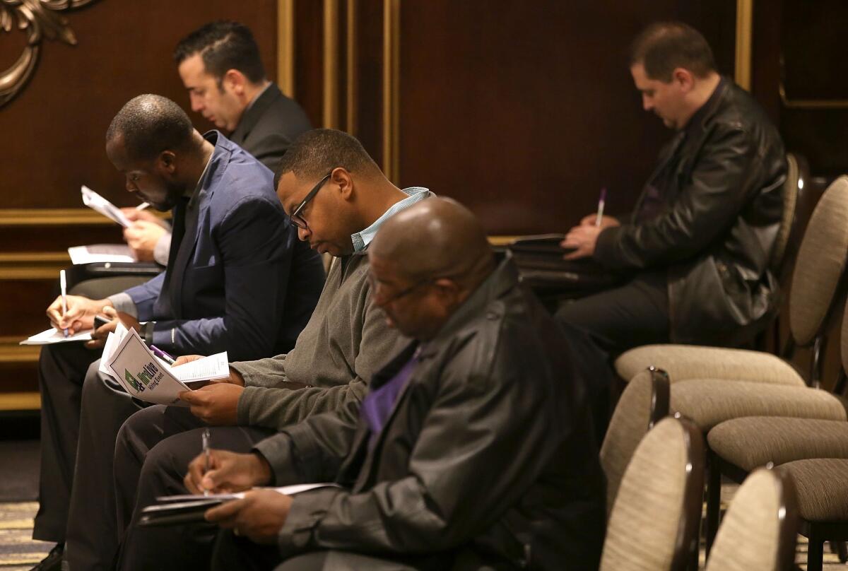 Job seekers fill out paperwork during the Nov. 12 HireLive Career Fair in San Francisco.