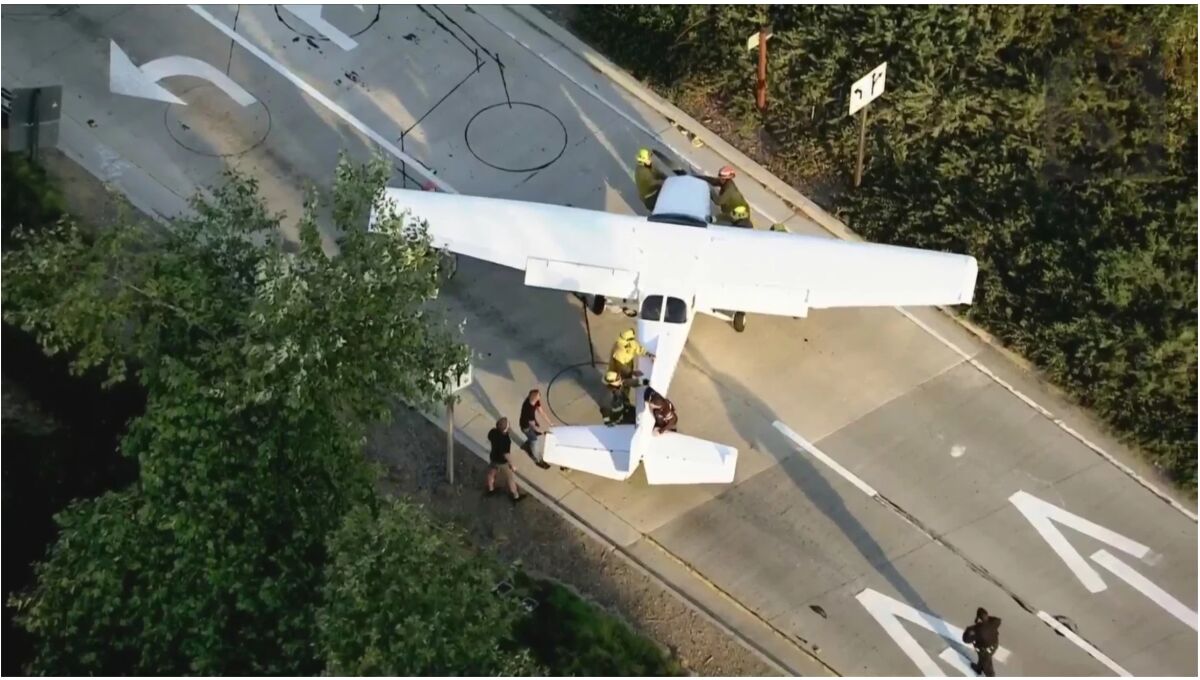 A small passenger plane is guided off a freeway