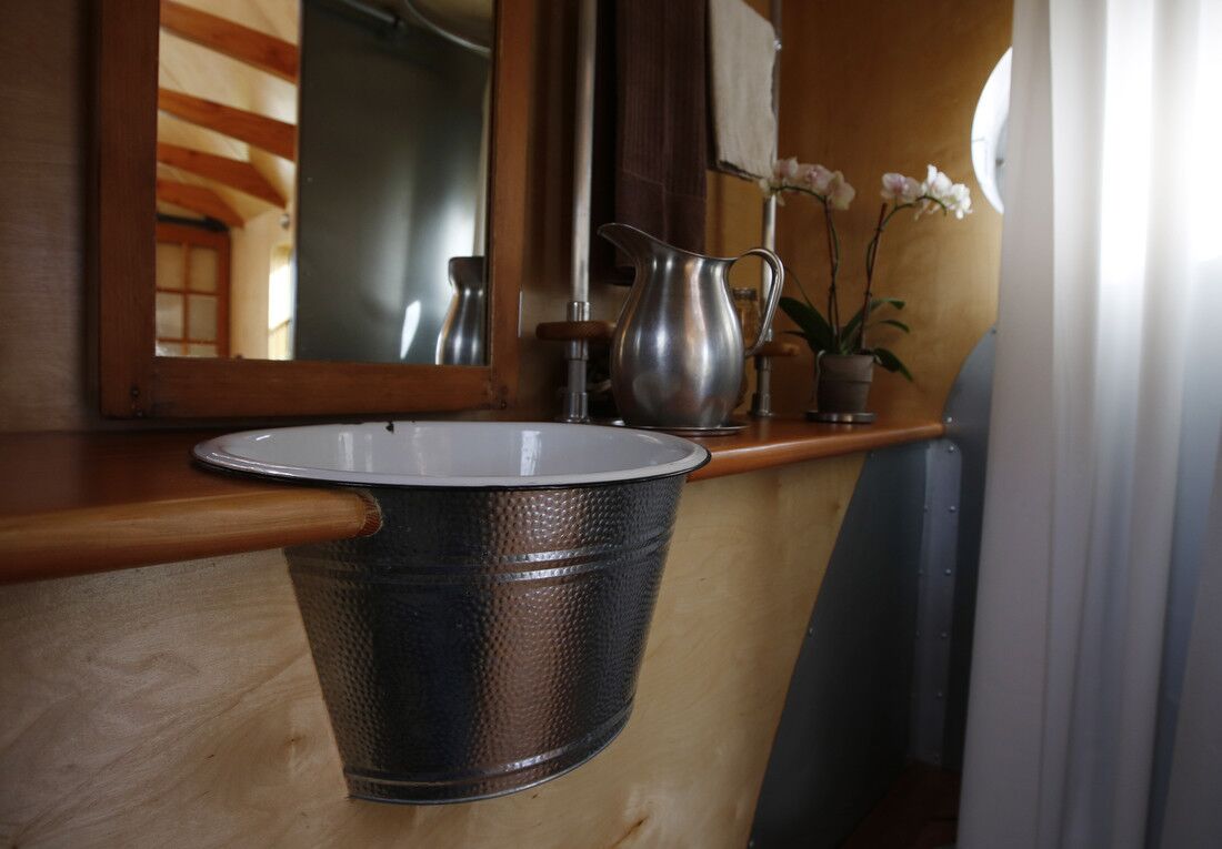 The bathroom's sink doesn't have a drain or running water; a pitcher is used instead.