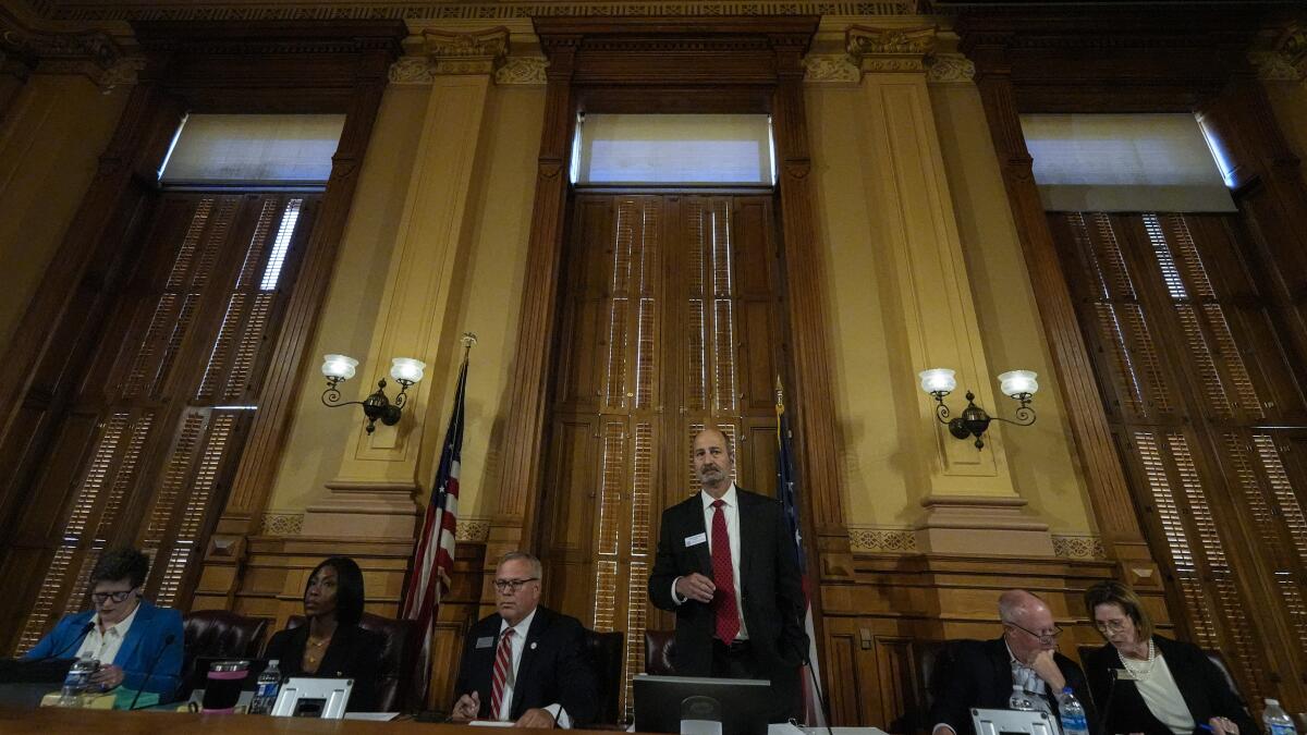 Georgia's State Election Board members sit side by side in an ornate room.