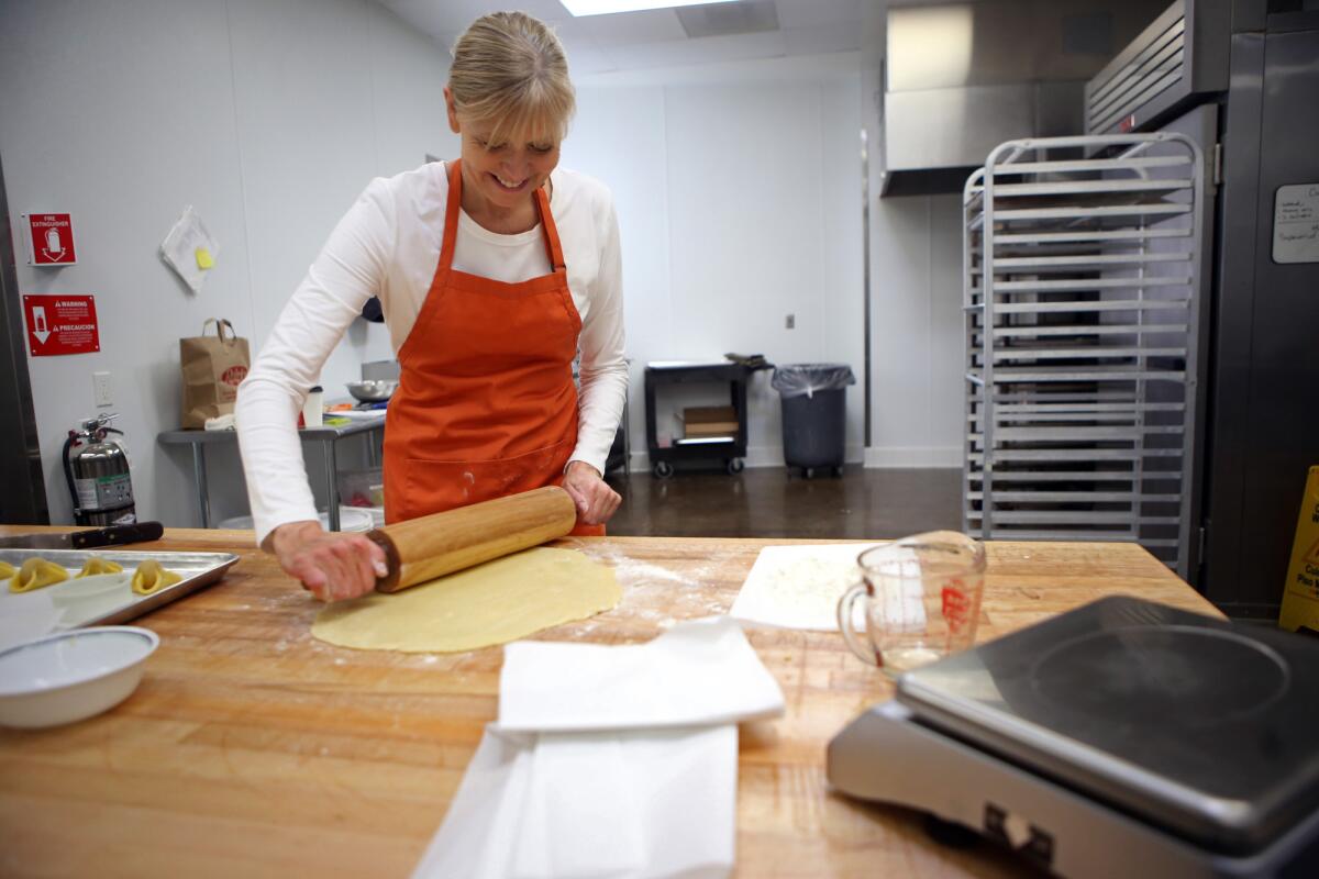 Baker Karen Hansen, owner of Copenhagen Pastry, rolls out the dough to make Napoleon hat cookies at her bakery in Pasadena on Dec. 7.