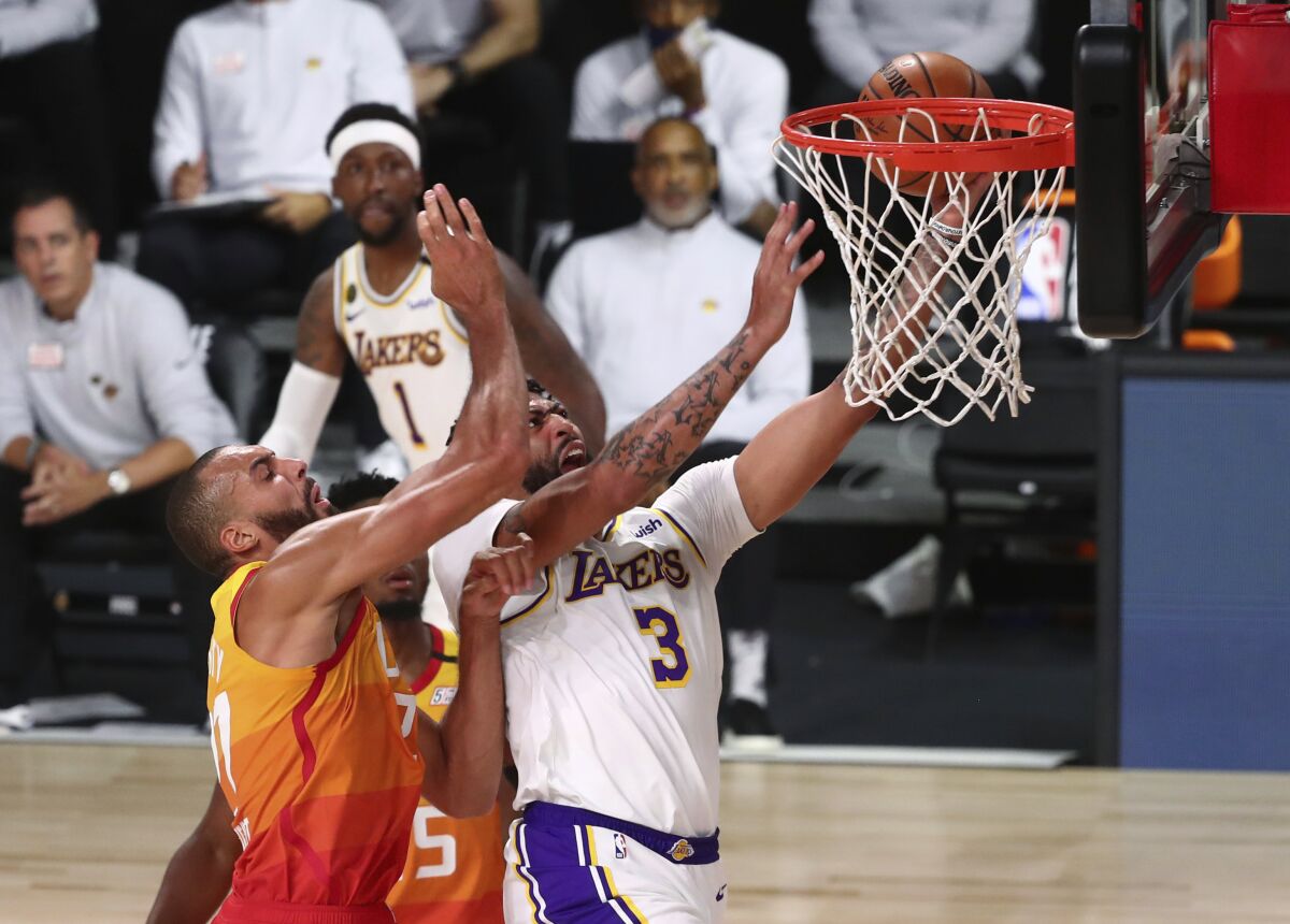 Los Angeles Lakers forward Anthony Davis (3) is fouled by Utah Jazz center Rudy Gobert, left, during the first half of an NBA basketball game Monday, Aug. 3, 2020, in Lake Buena Vista, Fla. (Kim Klement/Pool Photo via AP)