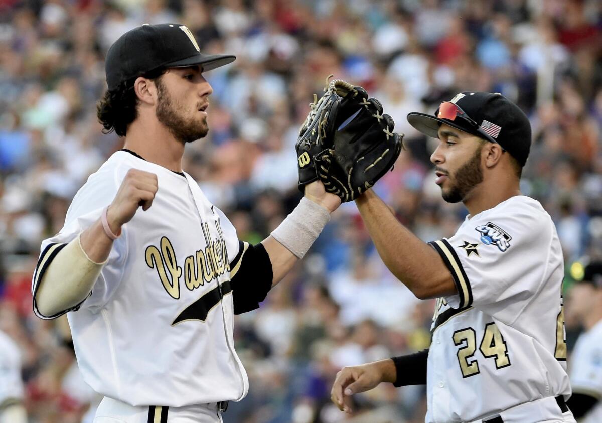 Vanderbilt shortstop Dansby Swanson, left, and Jordan Sheffield (24) exchange high-fives after a double play against TCU during the fourth inning of a College World Series game on Friday.