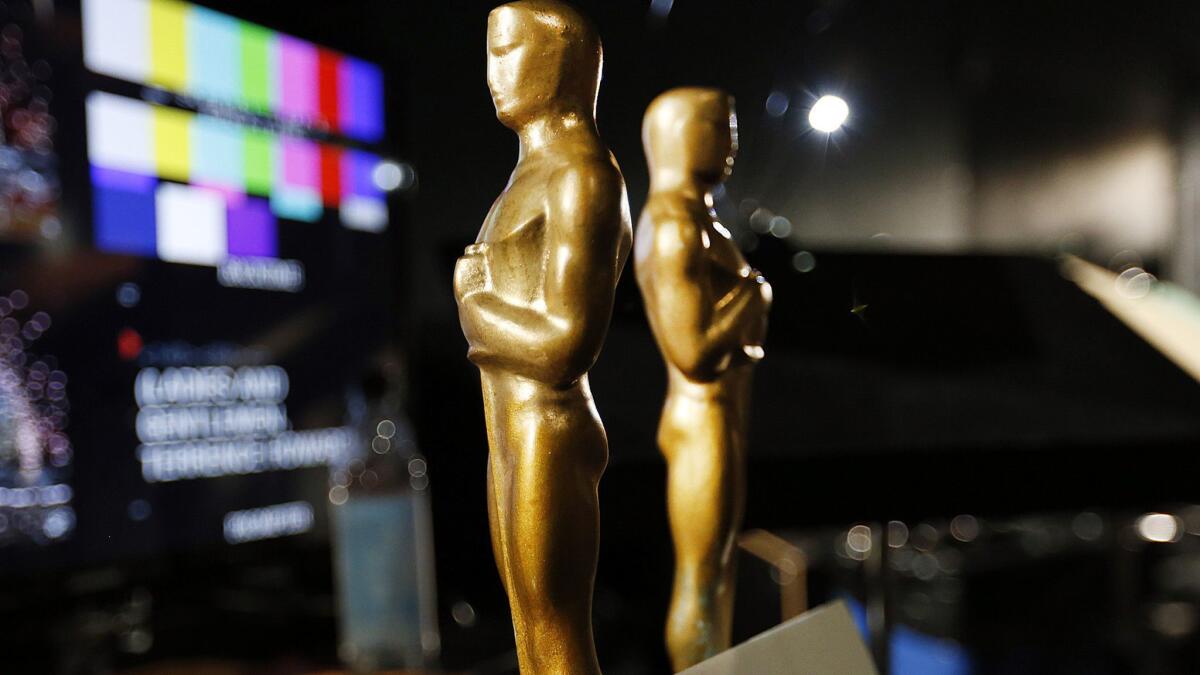 Two wooden stand-in Oscar statuettes are ready to be taken on stage during rehearsals in the Dolby Theatre