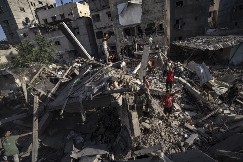 Palestinians look at the destruction after Israeli strikes on the Gaza Strip in Khan Younis, Saturday, Nov. 4, 2023. (AP Photo/Fatima Shbair)