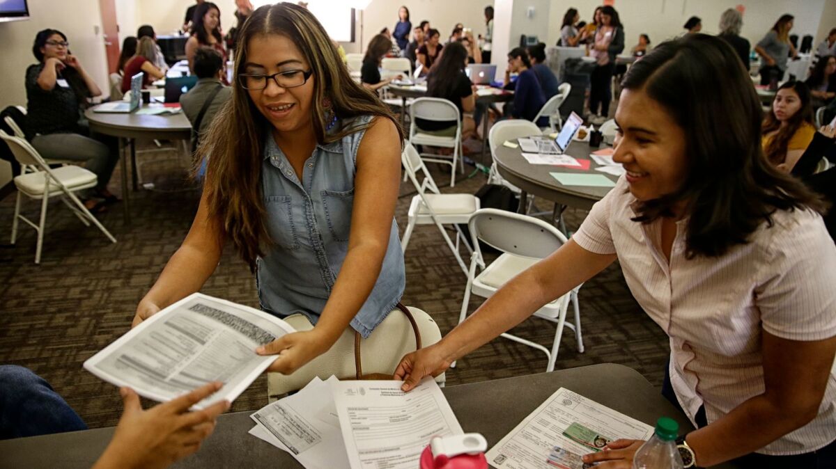 Vianey Romero, left, sorts renewal documents with Nohemi Martinez of the Mexican Consulate during a free DACA workshop hosted by the Loyola Immigrant Justice Clinic at Loyola Law School.