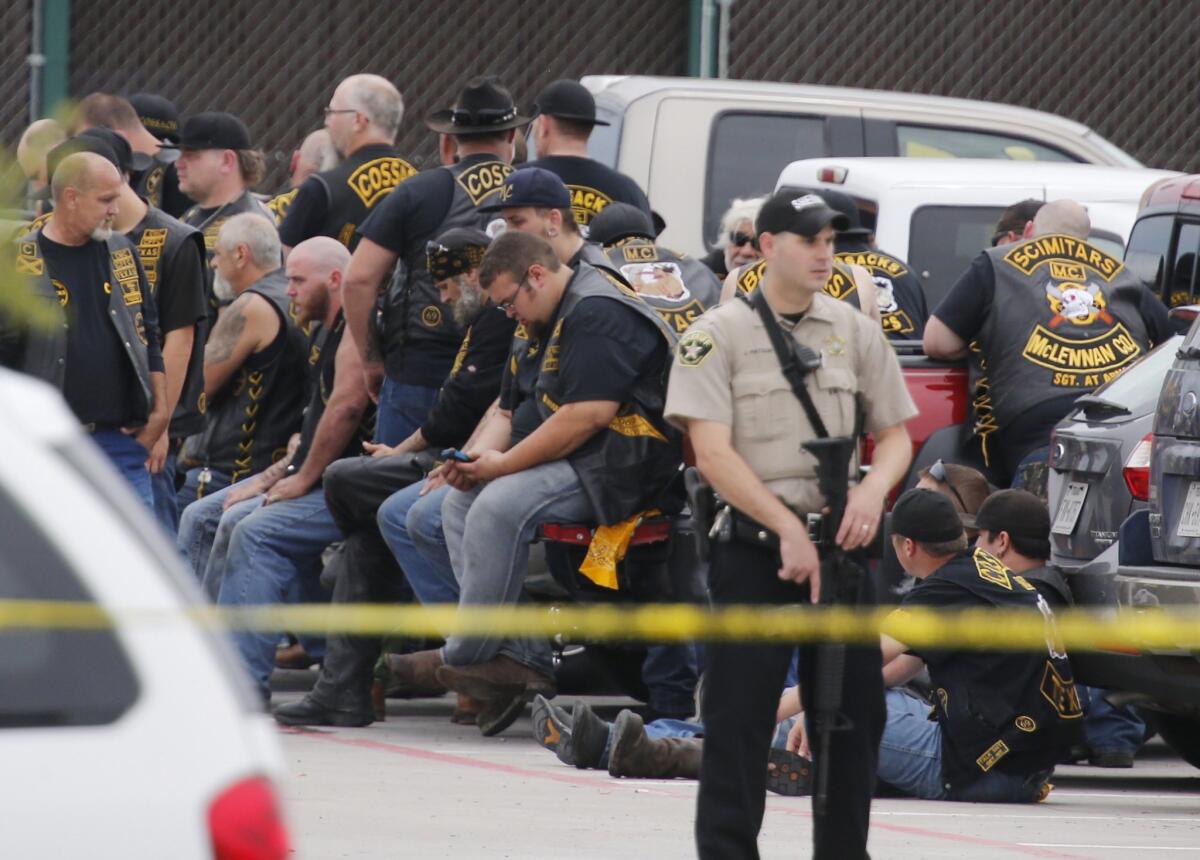 A deputy stands guard near a group of bikers in the parking lot of the Twin Peaks restaurant in Waco, Texas, following a brawl and shootout last May 17 that left nine dead.