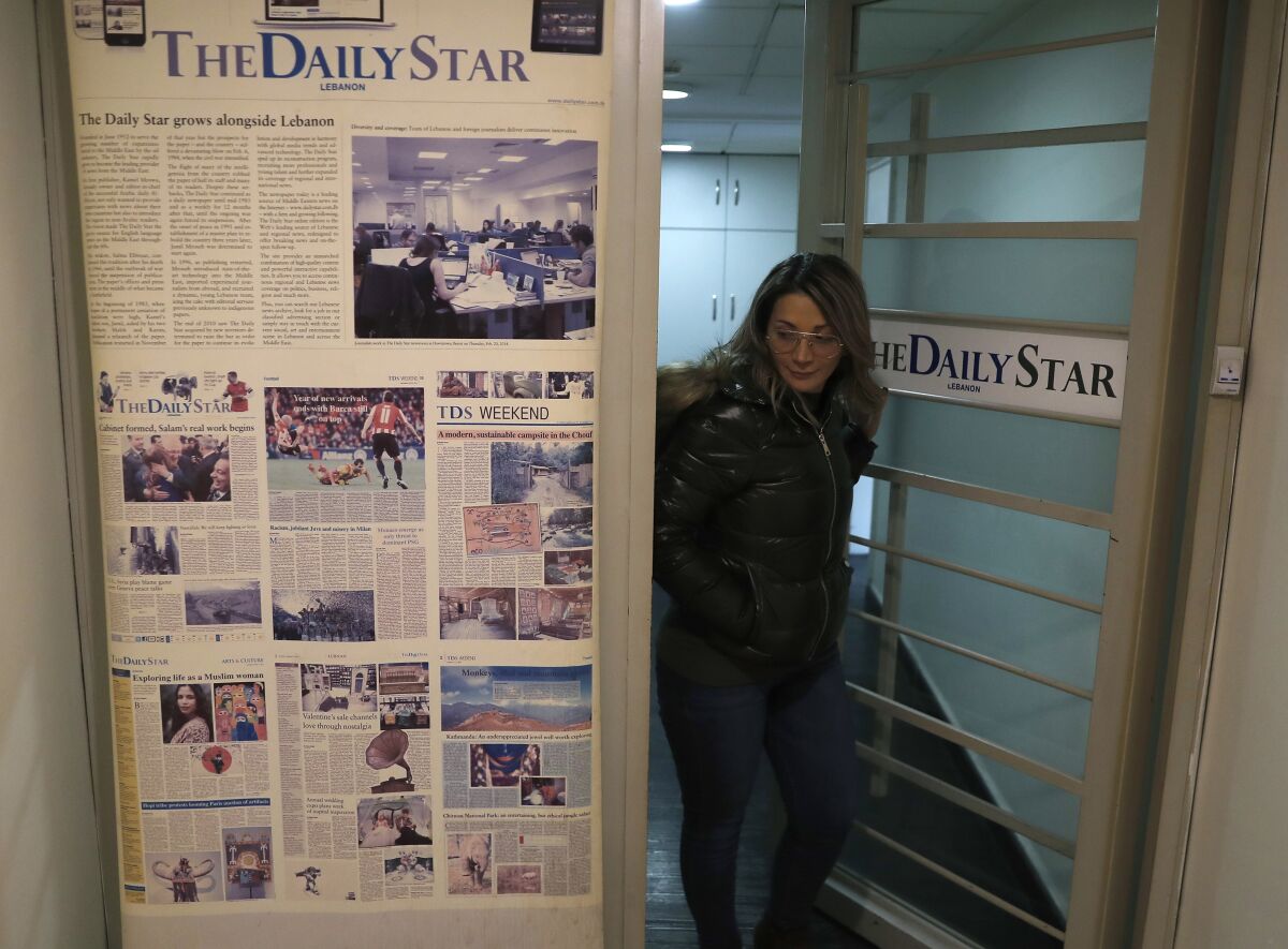 FILE - An employee of The Daily Star newspaper opens the main door of the newspaper office, in Beirut, Lebanon, Tuesday, Feb. 4, 2020. Lebanon's Daily Star newspaper, one of the leading English-language newspapers in the Arab world and Lebanon's oldest, has folded following a years-long financial struggle. Employees were formally informed of the decision to lay off all staff as of October 31 in an email sent to staff earlier this week and seen by The Associated Press Tuesday, Nov. 2, 2021. (AP Photo/Hussein Malla)