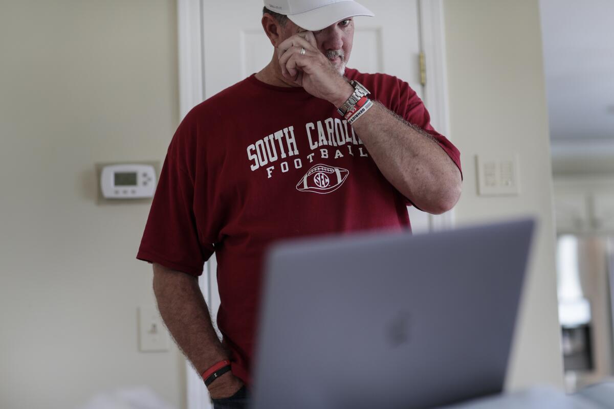 Mark Hilinski brushes a tear aside as he watches a video featuring his son, Tyler, playing Washington State.