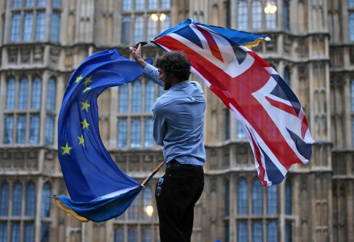 A man waves the British and European Union flags outside the Houses of Parliament in London on June 28, 2016.