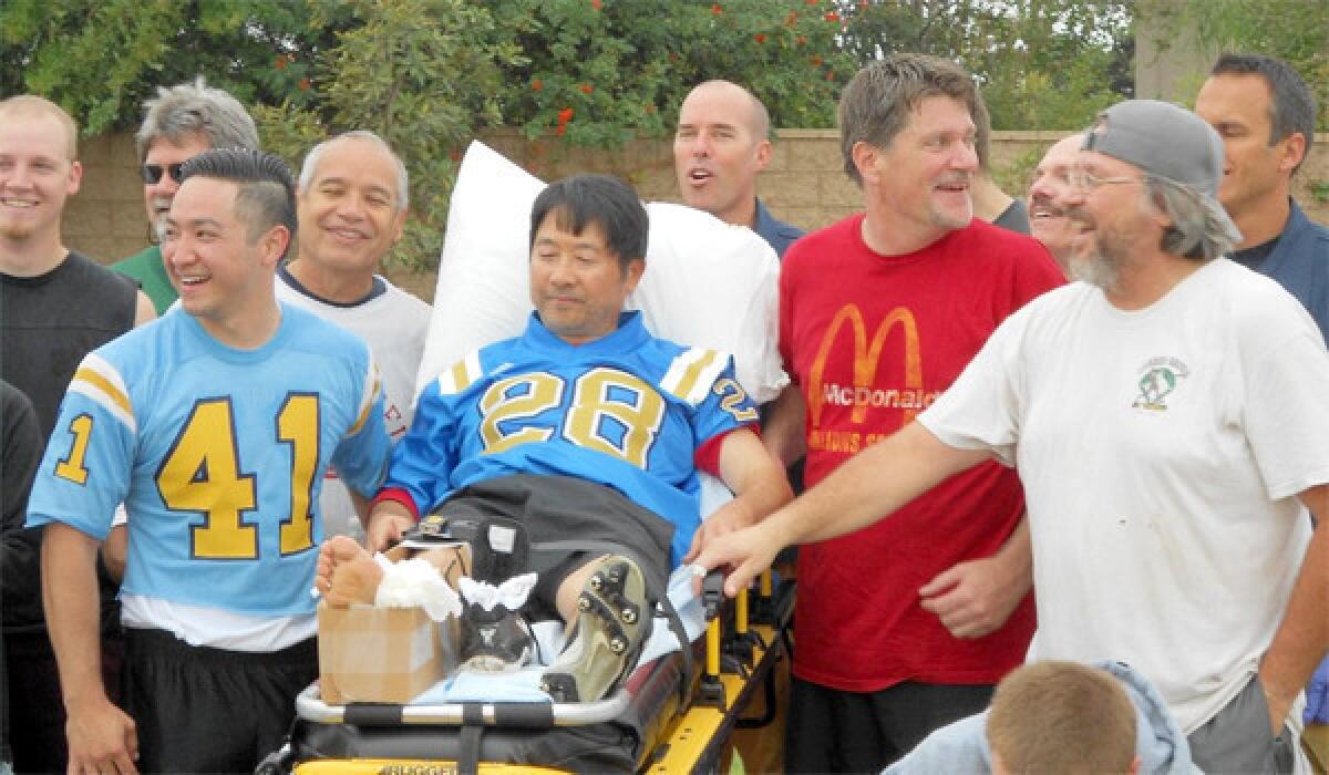 Ross Mishima on gurney, with teammates and the paramedics who tended to his broken ankle in last year's Mud Bowl.