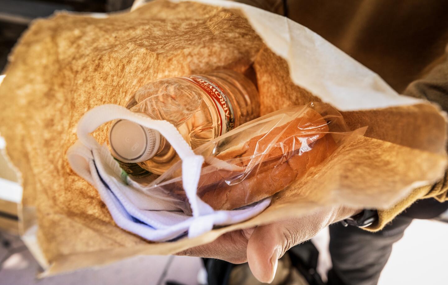 Bicycle Meals delivers bagged meals of a sandwich, chips and water, as well as a mask.