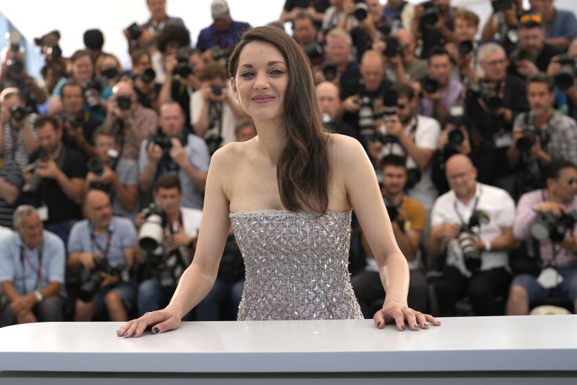 FILE - Marion Cotillard poses for photographers at the photo call for the film 'Brother and Sister' at the 75th international film festival, Cannes, southern France, Saturday, May 21, 2022. Oscar-winning actresses Marion Cotillard and Juliette Binoche, as well as other French stars of screen and music, filmed themselves chopping off locks of their hair in a video posted Wednesday Oct.5, 2022 in support of protesters in Iran. (AP Photo/Petros Giannakouris, File)