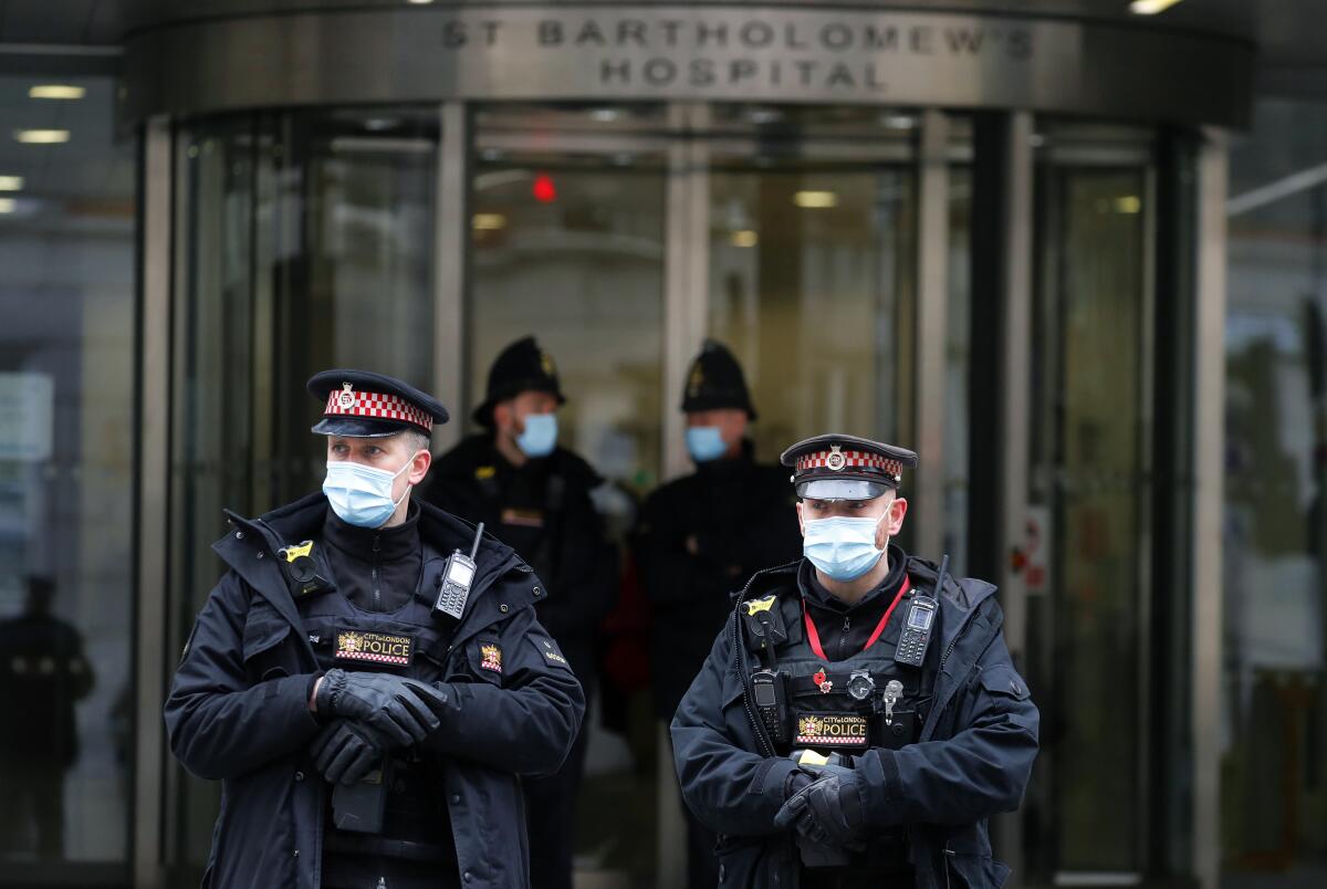 Police officers stand outside the main entrance of St Bartholomew's Hospital where Britain's Prince Philip is being treated in London, Friday, March 5, 2021. Buckingham Palace says Prince Philip has had a successful heart procedure in a London hospital. The palace says the 99-year-old Duke of Edinburgh, the husband of Queen Elizabeth II, "underwent a successful procedure for a pre-existing heart condition at St Bartholomew's Hospital." (AP Photo/Frank Augstein)