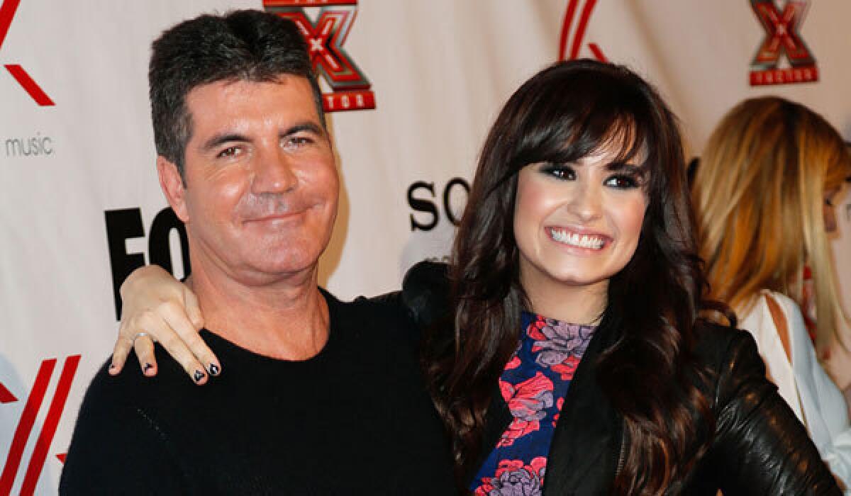 "X Factor" judges Simon Cowell and Demi Lovato at a party in 2012.