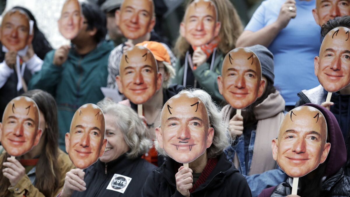 Seattle demonstrators hold up images of Amazon CEO Jeff Bezos as they protest Rekognition at company headquarters in October.