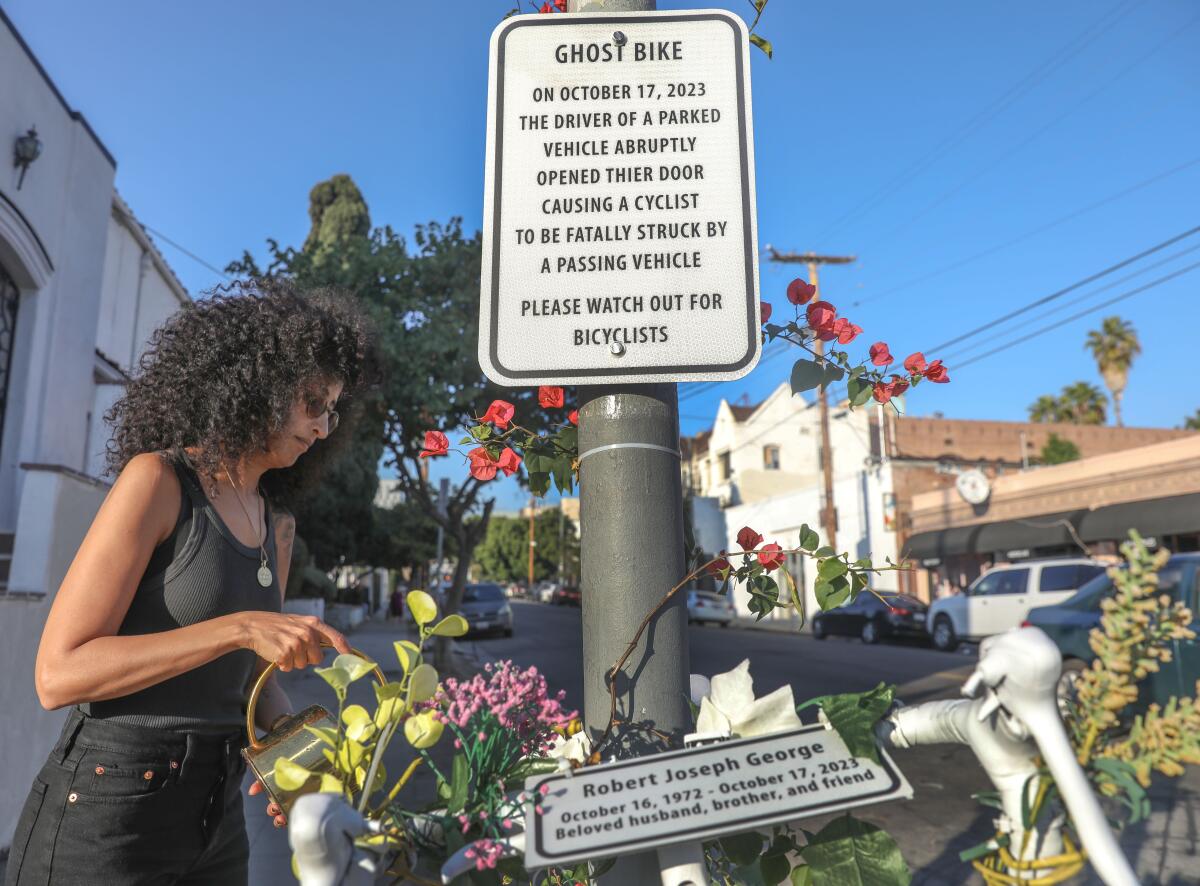 Yasmine Nasser Diaz pours water on the ghost bike vigil in the memory of her husband, cyclist Robert George.