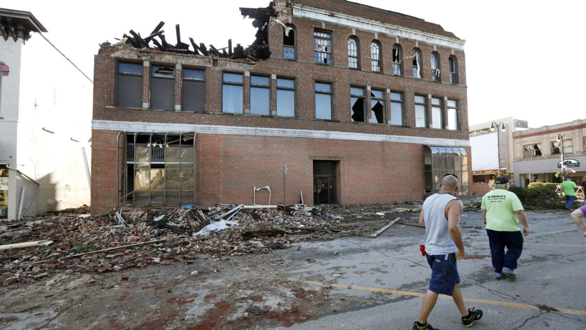 Residents pass a tornado-damaged building on Main Street in Marshalltown, Iowa, on July 19.