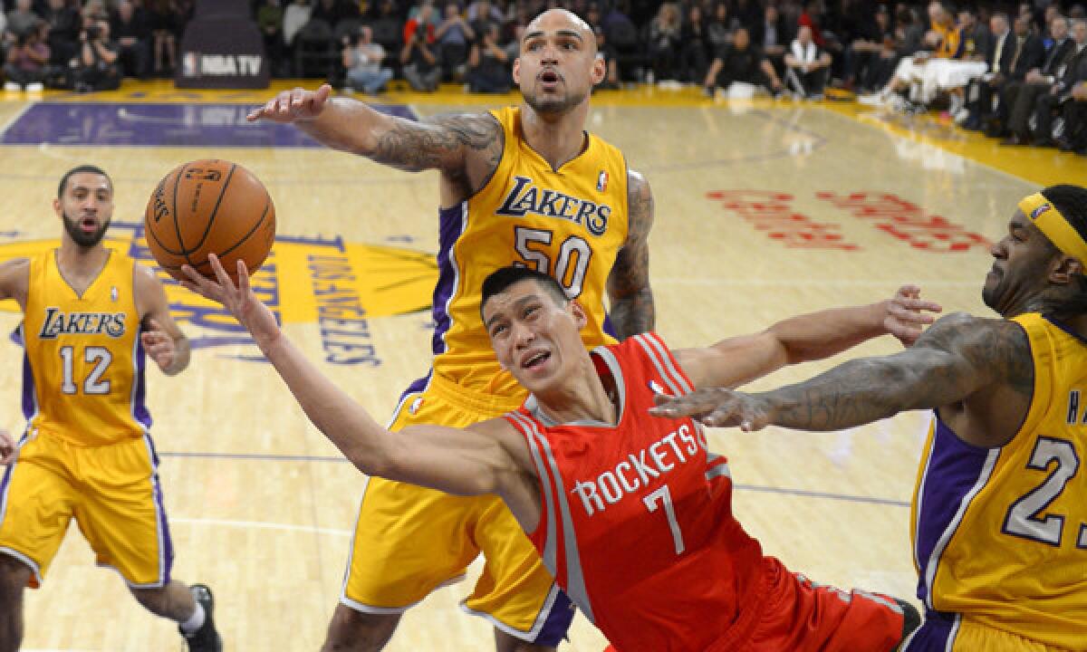 Houston Rockets guard Jeremy Lin, bottom, puts up a shot between Lakers teammates Kendall Marshall, left, Robert Sacre, center, and Jordan Hill during the Lakers' 134-108 loss on Feb. 19.