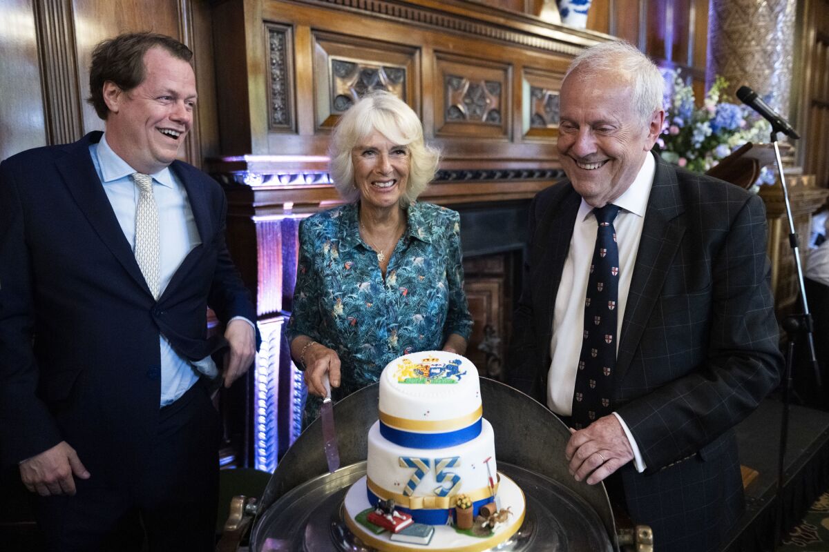 FILE - From left, Tom Parker Bowles, Camilla, Duchess of Cornwall and Gyles Brandreth during The Oldie Luncheon, in celebration of her 75th Birthday at National Liberal Club, London, July 12, 2022. Camilla, the Duchess of Cornwall, will celebrate her 75th birthday on Sunday, July 17, 2022 marking the occasion with a small family dinner at Prince Charles’ Highgrove estate in southwest England. (David Rose, Pool Photo via AP, File)