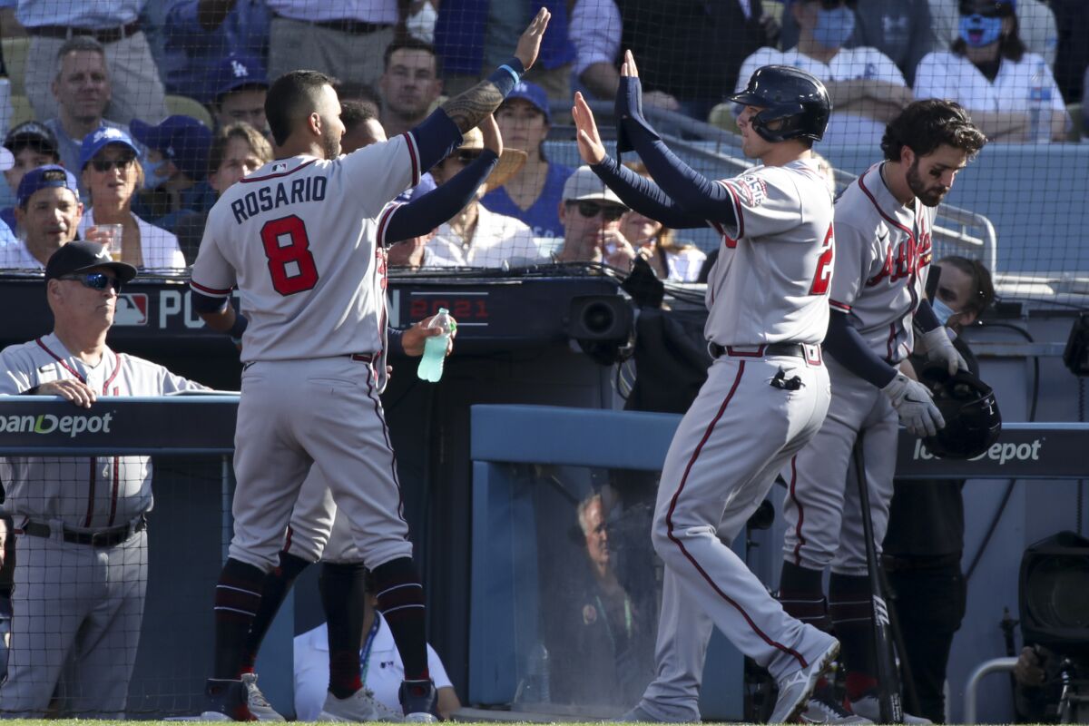 Atlanta's Austin Riley, right, celebrates with Eddie Rosario after scoring on a single by Adam Duvall.