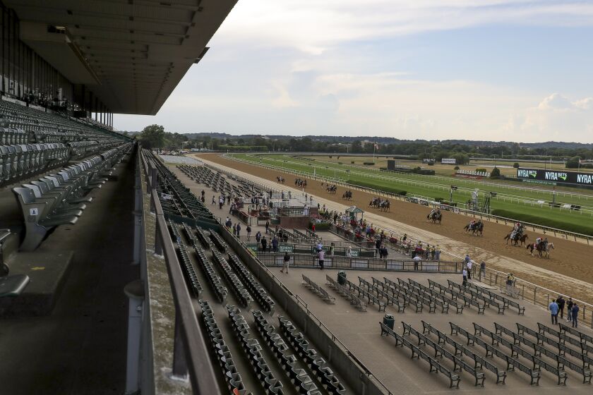 FILE - Horses parade in front of an empty grandstand a few minutes before post time for the 152nd running of the Belmont Stakes horse race, Saturday, June 20, 2020, in Elmont, N.Y. A little over a year from now, after it hosts the Belmont Stakes in 2024, Belmont Park is set to undergo a $455 million renovation of everything from the track surfaces to a brand new, smaller grandstand more fit for the sport in the modern era. (AP Photo/Seth Wenig, File)