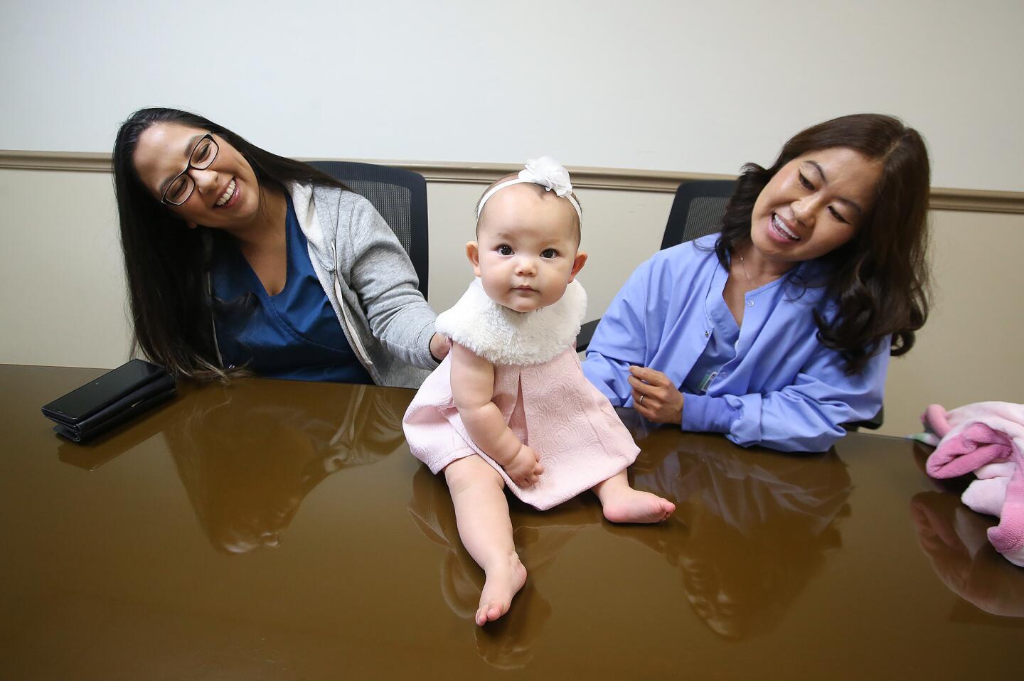 Baby Josephine spends time with surrogate Marcie Sisneros, left, and mother Michelle Ingenthron at Fountain Valley Regional Hospital & Medical Center, where Ingenthron is a labor and delivery nurse and Sisneros is a secretary in the neonatal intensive care unit.
