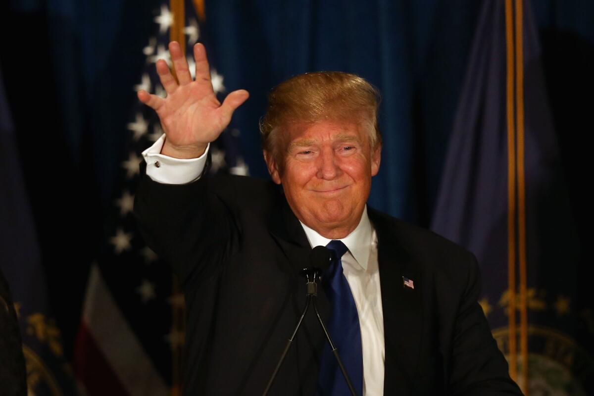 Republican presidential candidate Donald Trump waves to his supporters Tuesday in Manchester, N.H.