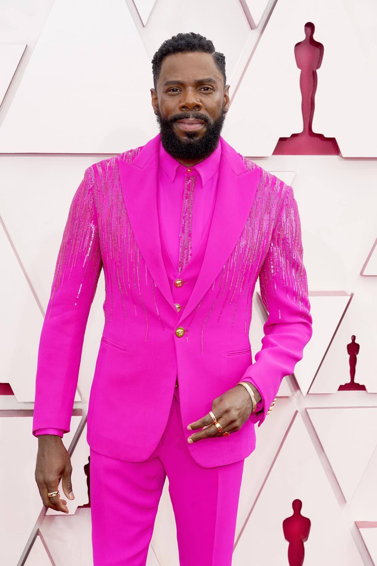 Colman Domingo arrives at the Oscars in a bright pink suit and shirt.