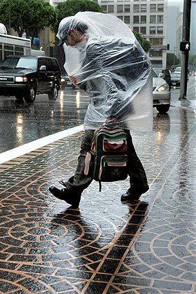 A pedestrian uses a bag to stay dry in downtown Los Angeles.