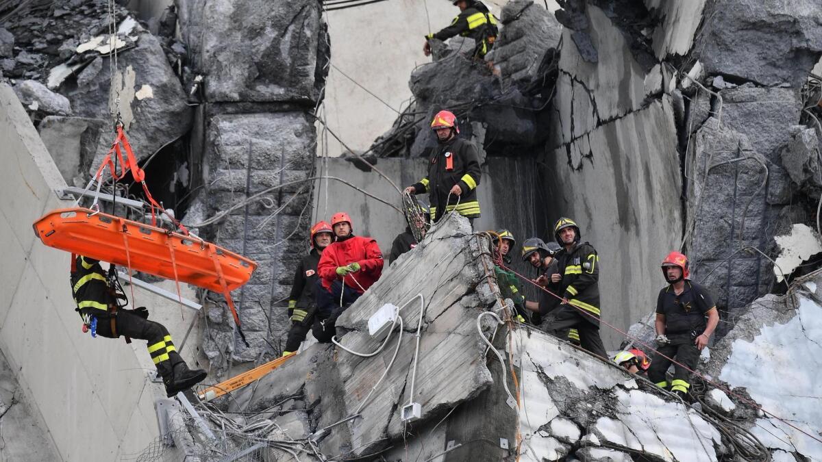 Rescuers recover an injured person after a highway bridge collapsed in Genoa, Italy, on Tuesday.
