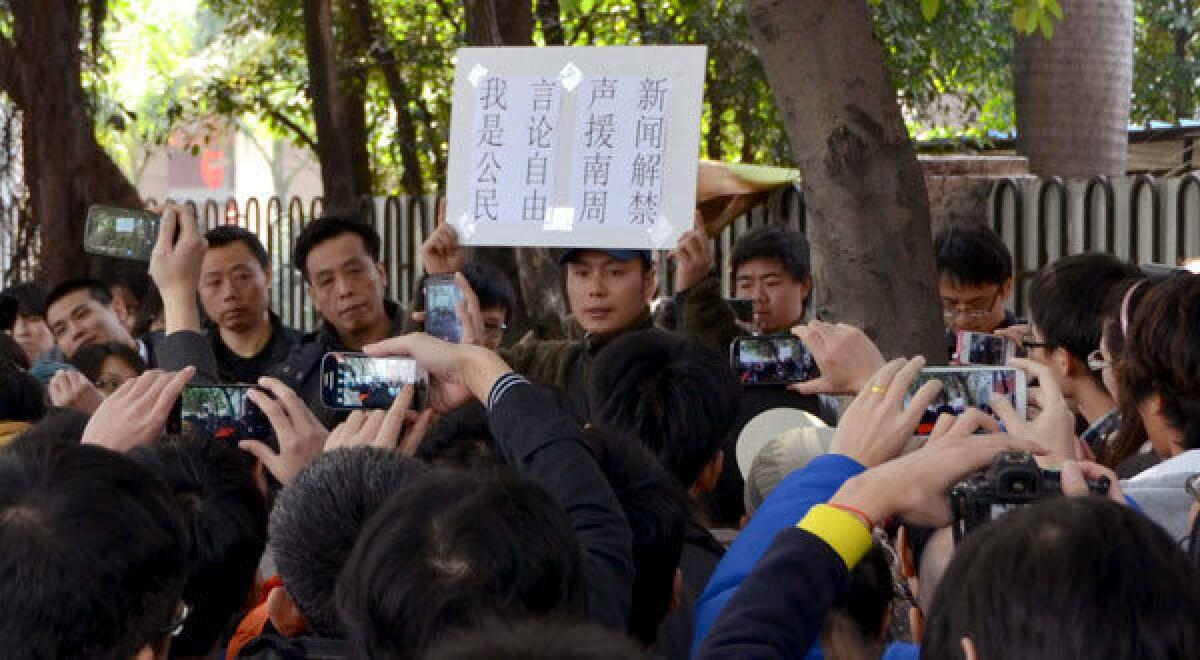 A protester holds aloft a banner which shows freedom of speech near the headquarters of Southern Weekly newspaper in Guangzhou, Guangdong province.