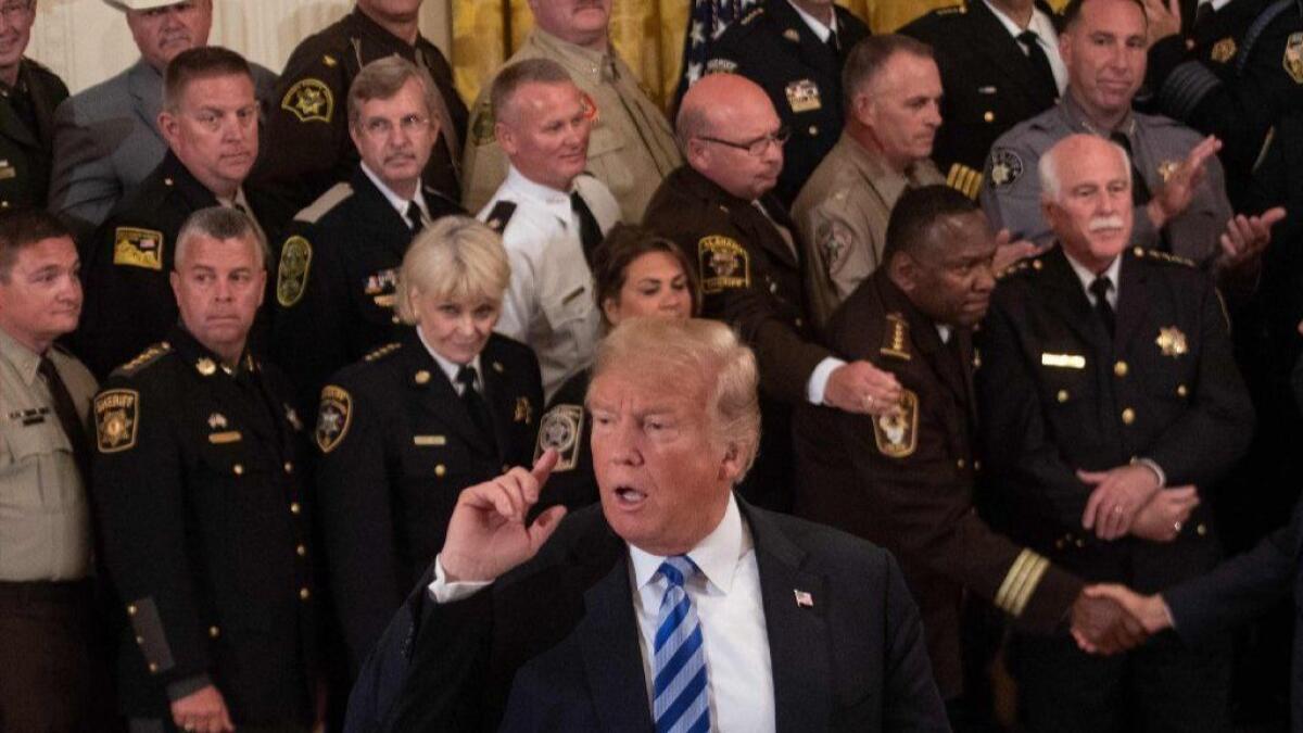 President Trump listens to a journalist's question during a meeting with sheriffs at the White House.