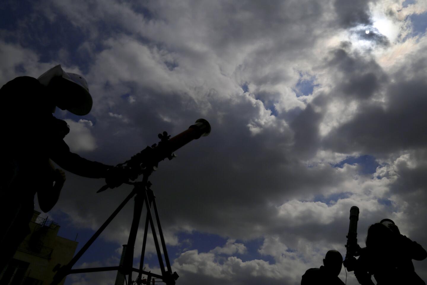 People set up telescopes as they watch an eclipse of the sun in Nicosia, Cyprus, on March 20, 2015.