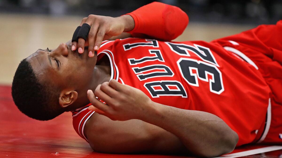Chicago's Kris Dunn lies on the floor after suffering a mouth injury following a dunk against Golden State on Wednesday.