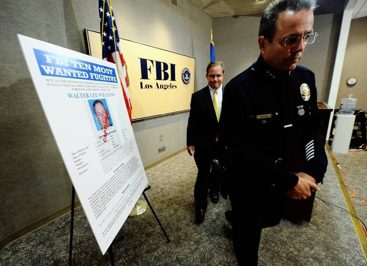 Assistant LAPD Chief Michel Moore, right, and Bill Lewis, FBI assistant director in charge of the Los Angeles office, discuss the arrest of former USC professor Walter Lee Williams.