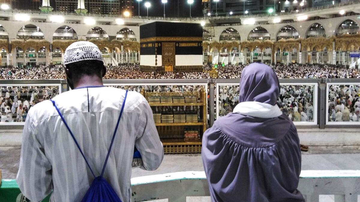 Muslim worshipers watch as others circumambulate around the Kaaba, Islam's holiest shrine, at the Grand Mosque in Saudi Arabia's holy city of Mecca on Aug. 17, 2018, prior to the start of the annual hajj pilgrimage.