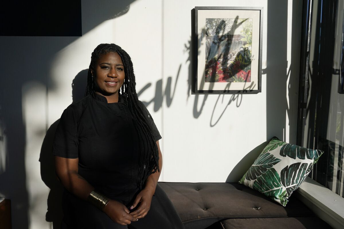 Kyndra McCrary, owner of Ooh La La Catering, poses for a portrait at her restaurant, Swift Cafe, Tuesday, Feb. 8, 2022, in Los Angeles. Her catering company got hired to provide food for performers working the Super Bowl, and for an NFL business networking event the previous week. “I think there will be a lasting impact because people who will get to try our food will remember us,” said McCrary, 40. (AP Photo/Marcio Jose Sanchez)