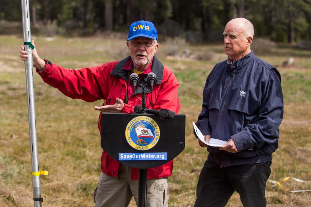 California Gov. Jerry Brown, right, looks on as Frank Gehrke, chief of snow surveys for the California Department of Water Resources, describes the average height of the snow near Lake Tahoe. The green tape at his right hand is a little more than five feet high.