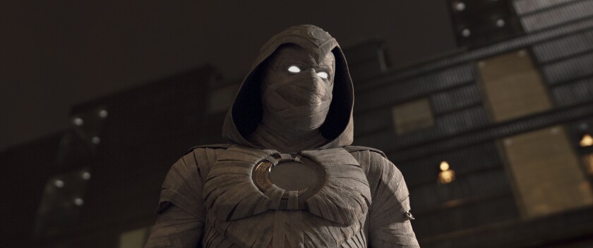 A masked superhero with glowing eyes in a hooded cloak.