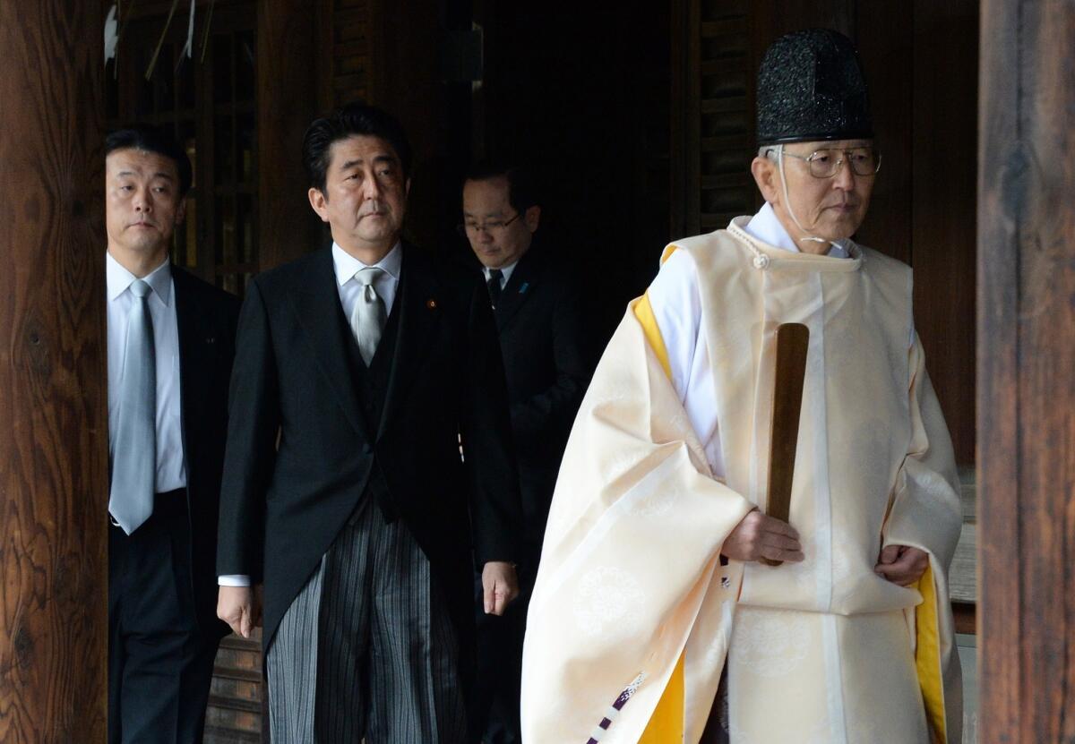 Japanese Prime Minister Shinzo Abe follows a Shinto priest Thursday into the Yasukuni shrine to Japanese World War II dead, including 14 convicted war criminals.